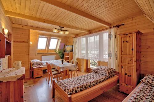 a room with two beds and a table in a cabin at Pokoje Gościnne Pod Giewontem in Zakopane