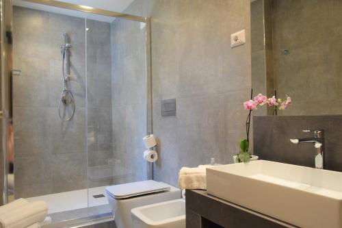 a bathroom with a shower and a toilet and a sink at Hotel Continental in Taormina