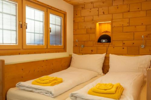 Dos camas en una habitación con toallas. en Chalet Schtuba en Zermatt