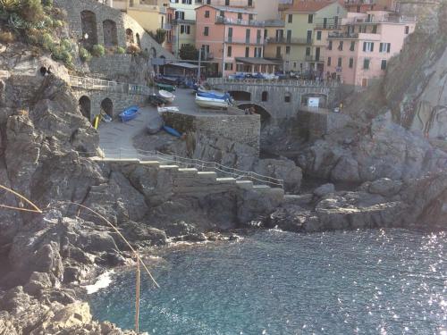 eine Gruppe von Menschen, die auf einer Treppe neben dem Wasser sitzen in der Unterkunft Casa LA MARINA in Manarola