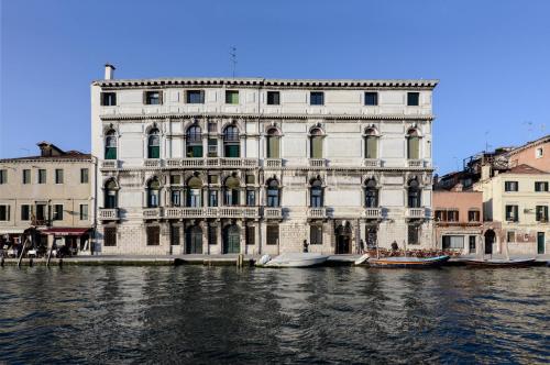 um edifício sobre a água com barcos à sua frente em Rousseau's Apartment em Veneza