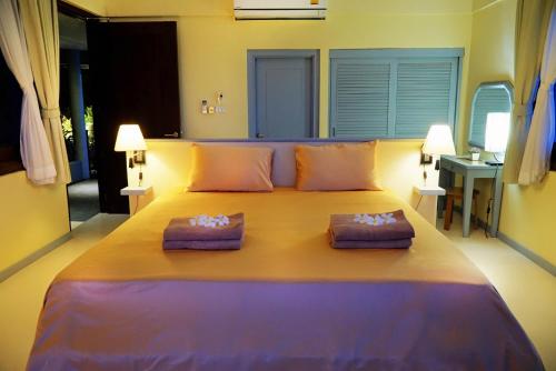 a large bed in a room with two pillows on it at Villa Sapphire in Laem Set Beach