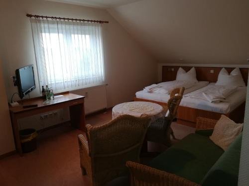 a bedroom with two beds and a desk and a television at Weinbau & Pension "8Zeilen" in Golk