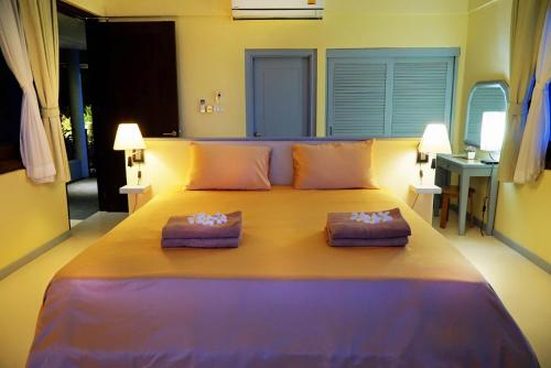 a large bed in a room with two pillows on it at Villa Emerald in Laem Set Beach