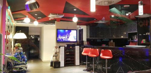 a bar with red stools and a tv in a store at 51 Spring in Wulai