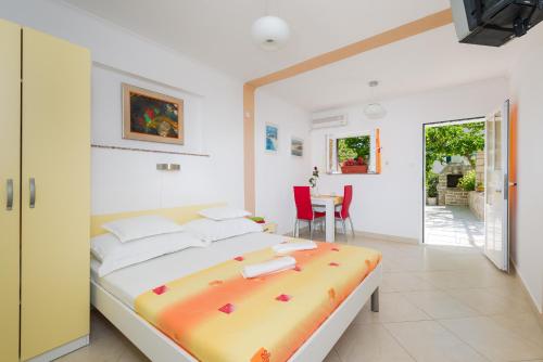 a bedroom with a bed and a table and chairs at Apartments Nada in Bol