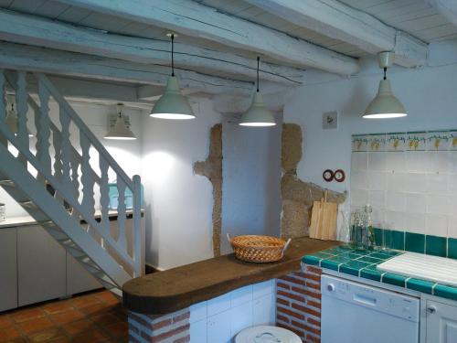 Una cocina con encimera y escalera con luces. en Abejas 1 de El Vergel de Chilla, en Candeleda
