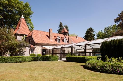 a large house with glass windows and a yard at La Bergerie de Lives in Namur