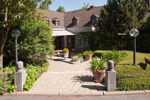 a brick walkway in front of a house with potted plants at La Bergerie de Lives in Namur