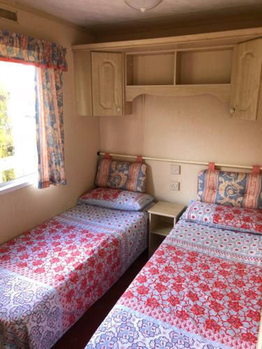 a small room with two beds and a window at 35 Glenfinart Park in Dunoon