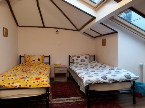 two twin beds in a room with windows at Motor House Unirii in Bucharest