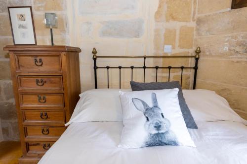 a bed with a stuffed rabbit on the pillows at The Burrow Guest House in Tarxien