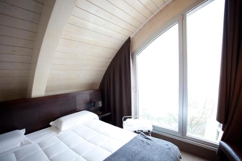 a bedroom with a bed and a large window at Hotel Mosaico in Ravenna