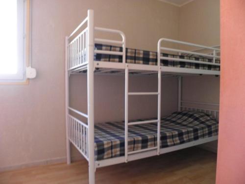 two white bunk beds in a room at les lavandes in Lablachère