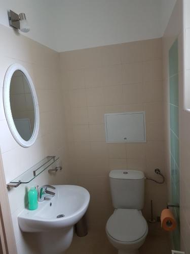 a bathroom with a white toilet and a sink at Apartments For You in Olimp