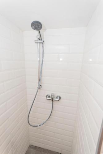 a shower with a shower head in a bathroom at The Burrow Guest House in Tarxien