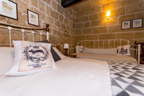 a bedroom with a white bed with a pillow on it at The Burrow Guest House in Tarxien