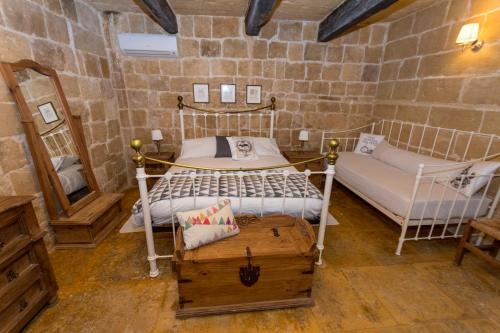 a bedroom with two bunk beds in a stone wall at The Burrow Guest House in Tarxien