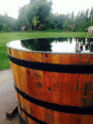 a large wooden barrel with water in a field at Cabañas de Campo Colbún in Colbún