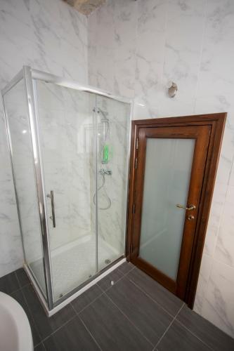 a shower with a glass door in a bathroom at The Burrow Guest House in Tarxien