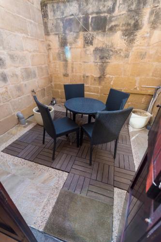 a patio with a table and chairs and a toilet at The Burrow Guest House in Tarxien