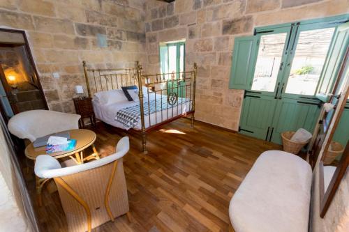 a bedroom with a bed and a table and chairs at The Burrow Guest House in Tarxien