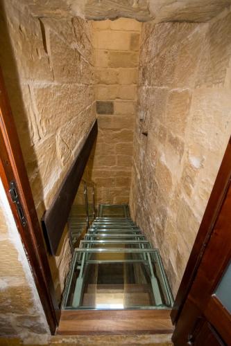 a staircase with a glass floor in a building at The Burrow Guest House in Tarxien