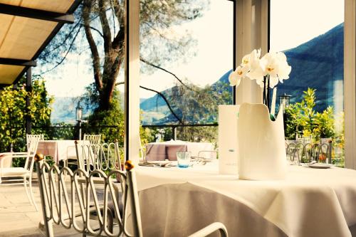 een tafel met witte bloemen in een vaas erop bij Villa Sasso in Merano