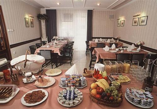 a dining room with tables and plates of food at Apollo Motel in Kecskemét