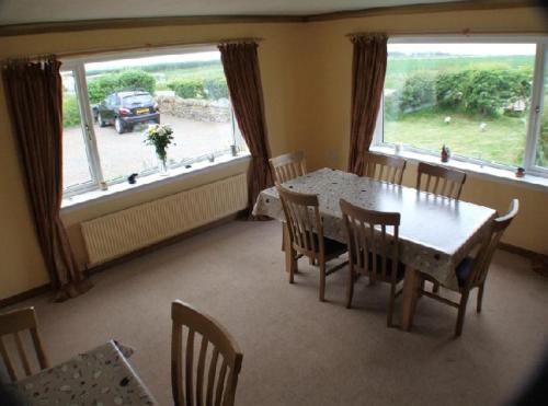a dining room with a table and chairs and a large window at The Hawthorns B & B in Mey