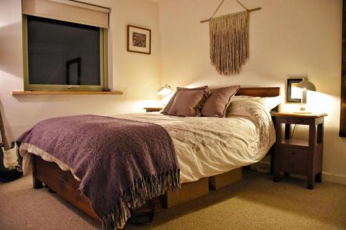 a bedroom with a large bed and a television at Cosy Cottage in Glencoe