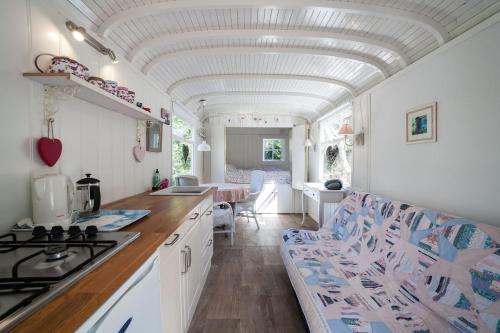 eine Küche mit weißen Schränken und einer Decke in der Unterkunft pipowagen Blagour gelegen aan waterbron in Lachapelle-Auzac