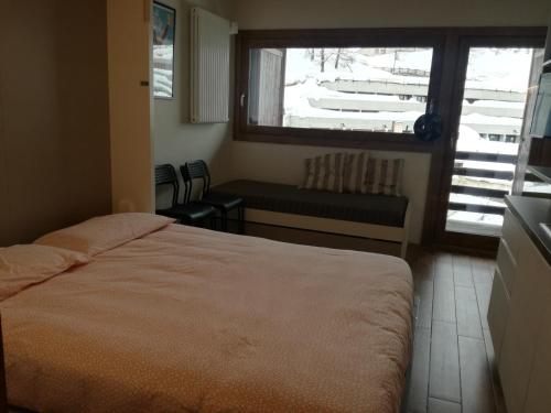 ブレウイル・チェルヴィナイアにあるCielo Alto Studio Apartment with wifiのベッドルーム1室(ベッド1台付)、窓(ベンチ付)