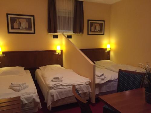 a hotel room with two beds and a table at Virgo B&B Biznes Rumia in Rumia