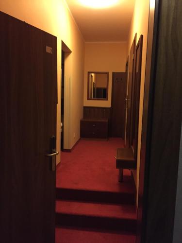 a hallway with a red carpet and a room with a mirror at Virgo B&B Biznes Rumia in Rumia
