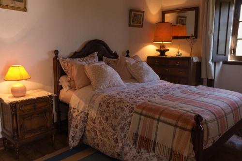 a bedroom with a large bed and two lamps at Casa Rústica in Serra do Bouro
