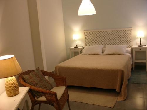 - une chambre avec un lit, une chaise et une lampe dans l'établissement Playa y Montaña Faura-Valencia, à Faura