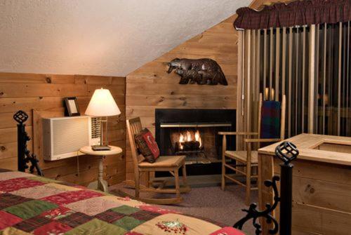 a bedroom with a bed and a fireplace at Inn at Ellis River in Jackson
