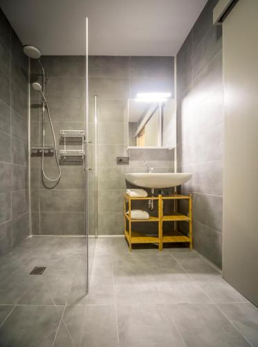 a bathroom with a sink and a shower at Apartahotel 5dos5 in Oviedo