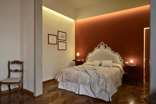 1 dormitorio con 1 cama grande y 1 silla en Villa Le Facezie B&B, en Terranuova Bracciolini