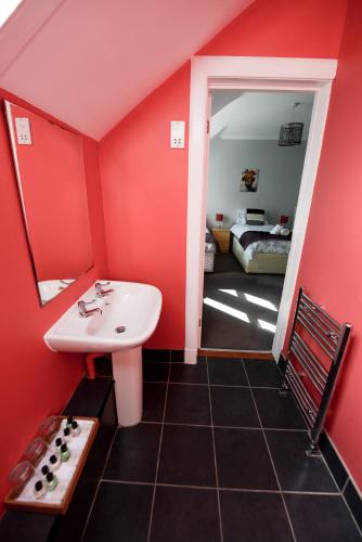 a bathroom with a sink and a red wall at No. 1 Caberfeidh in Fort William