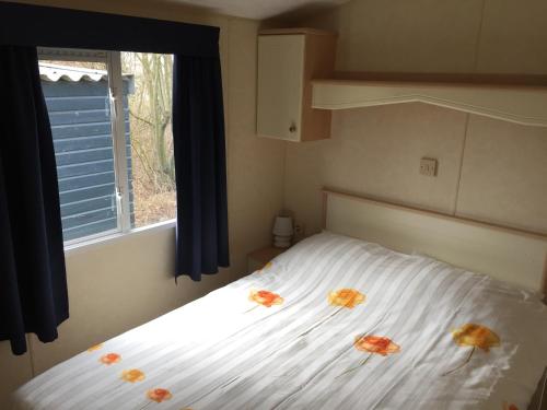 ein Schlafzimmer mit einem Bett mit drei Blumen drauf in der Unterkunft Chalet Casa Cowabunga in Earnewâld