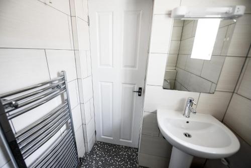 a white bathroom with a sink and a mirror at No. 1 Caberfeidh in Fort William