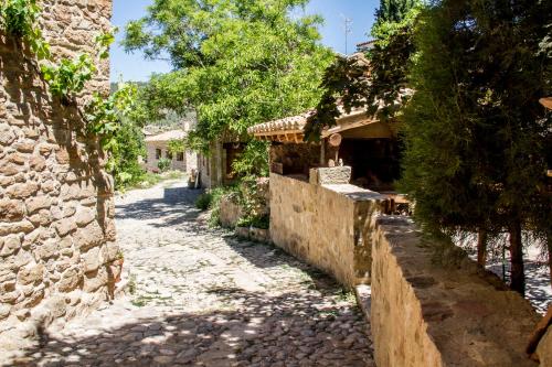 an alley in a village with a stone building at La Casa de Los Moyas in Olba