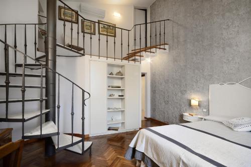 a bedroom with a spiral staircase next to a bed at Villa Le Facezie B&B in Terranuova Bracciolini