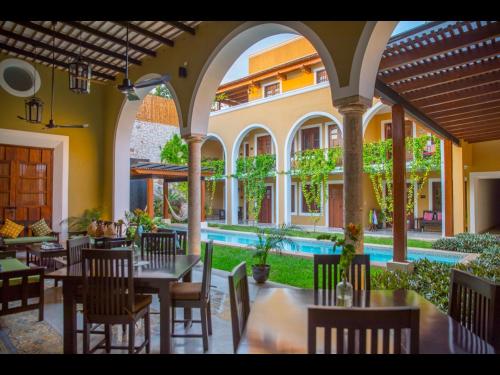 a restaurant with tables and chairs and a pool at Boutique by The Museo in Mérida