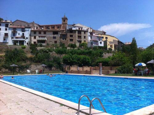 a large blue swimming pool with buildings in the background at La Casa de Los Moyas in Olba