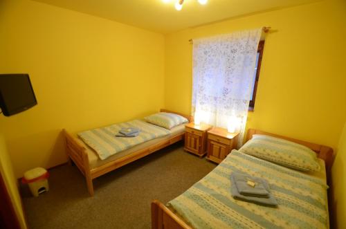 two beds in a small room with a window at Salas-Partizanske in Partizánske