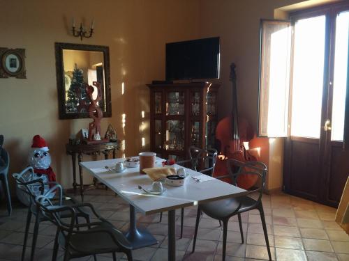 een kamer met een tafel met stoelen en een kerstman clausule bij Palazzo Madeo - Residenza d'Epoca in Crosia