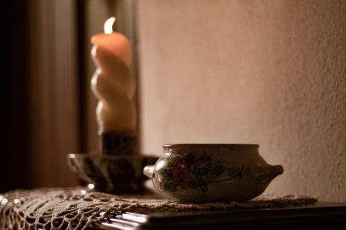 a candle on a table with a tea pot and a candle at Casa Rústica in Serra do Bouro